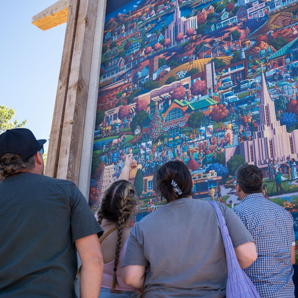 People standing looking up at the Dowdle Puzzle Mural